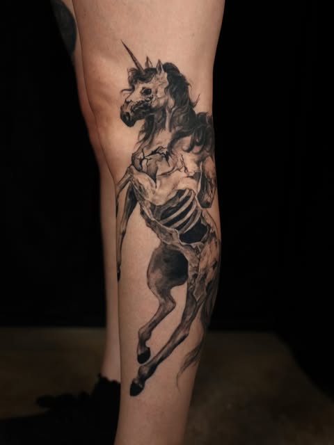 Black and grey skeletal horse tattooed on a lower leg